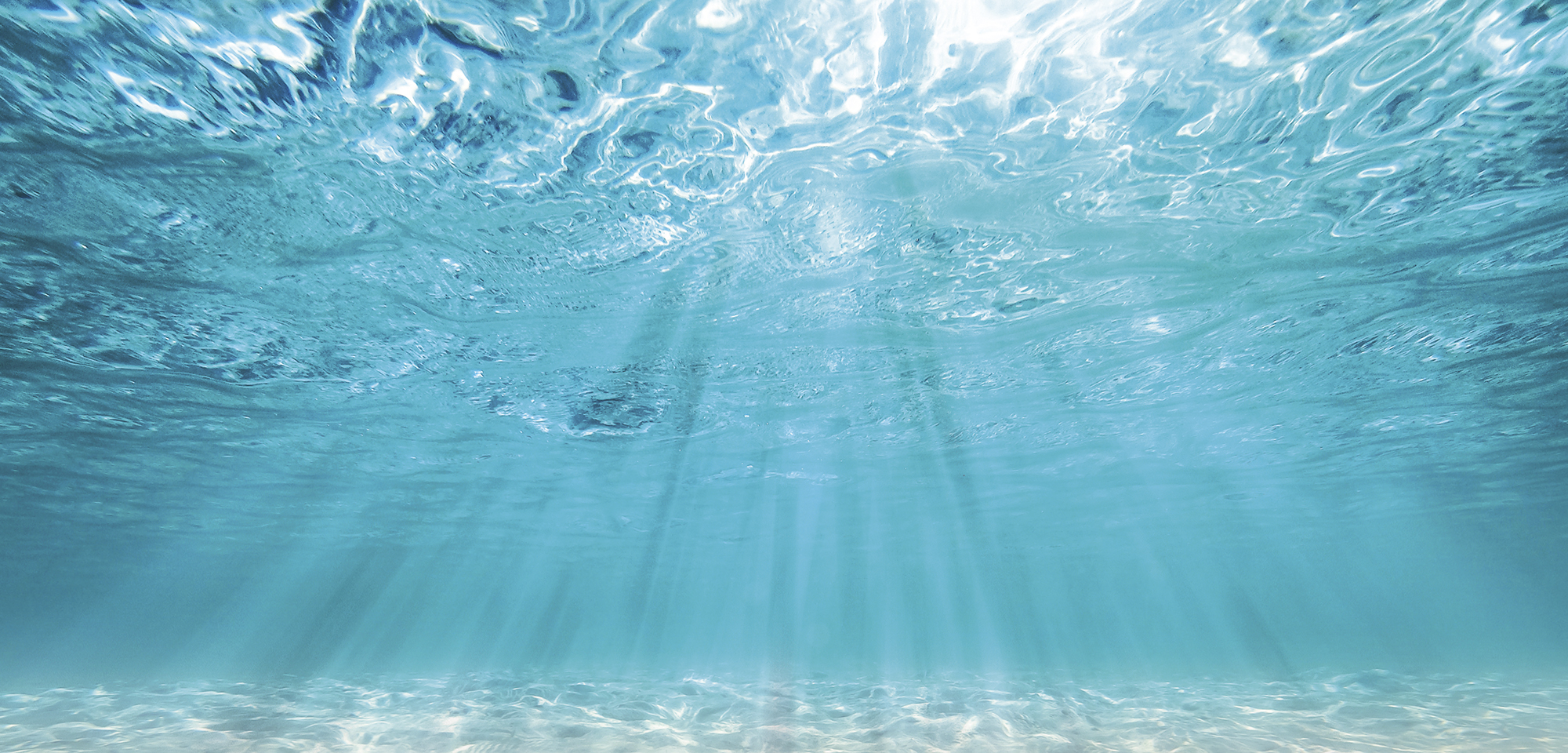 underwater turquoise background  deep blue sea and beautiful light rays with sandy floor